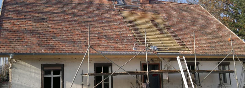 Eingerüstetes Bestandsgebäude mit Arbeiten am Dach